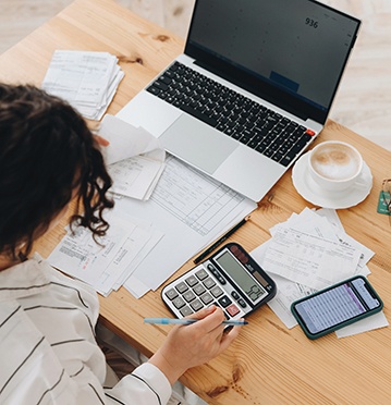 Woman sitting at computer, calculating her budget