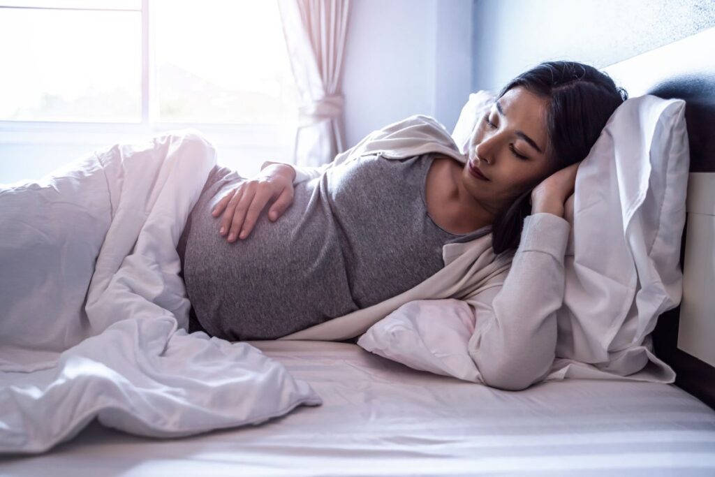 A pregnant woman lying in bed.